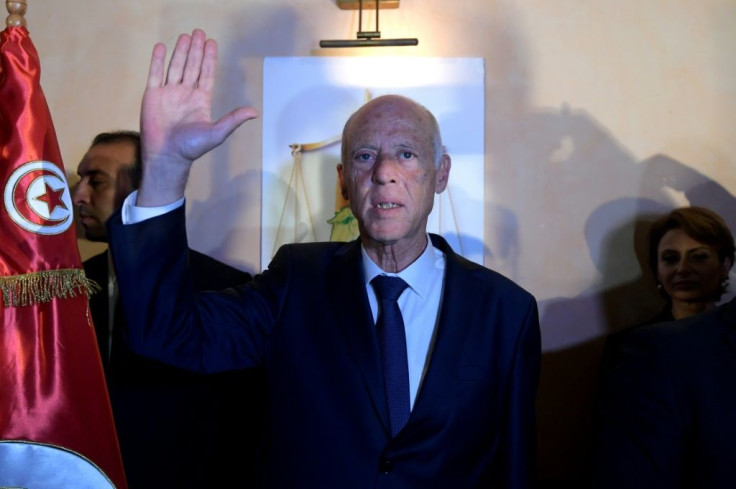 Conservative academic Kais Saied (C), flanked by his wife Ichraf Chebil (R), celebrates his victory in the Tunisian presidential election