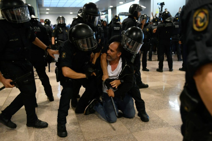 Police wrestle down a protester at Barcelona's El Prat airport as demonstrators headed there en masse