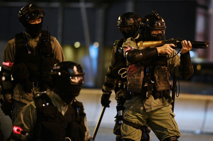 A Hong Kong riot policeman points a weapon towards pro-democracy protesters rallying in support of proposed US legislation -- police said they were facing increasingly dangerous attacks from demonstrators, who say officers use excessive force