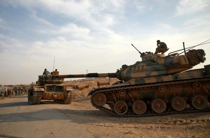 Turkish troops with American-made M60 tanks move near the village of Qirata in Syria