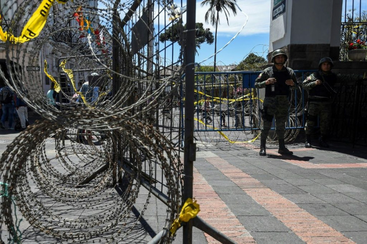 Soldiers stand guard outside the presidential palace in Quito