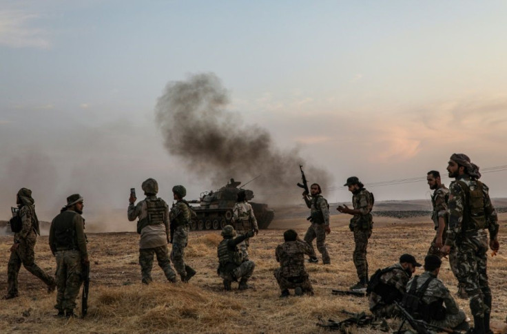 Turkish soldiers and Turkey-backed Syrian fighters gather on the northern outskirts of the Syrian city of Manbij