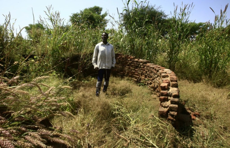 Sudanese villager Siddiq Youssef checks the remains of his house which was burnt 15 years ago in the village of Shattaya one of several in the Darfur region that faced the brunt of the attack unleashed by the notorious Janjaweed militia