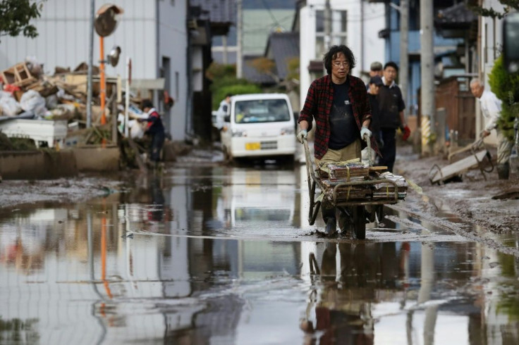A man removes muddy items at a flood-affected area in Nagano -- Japan's government pledged financial support to affected regions without specifying how much aid it would set aside