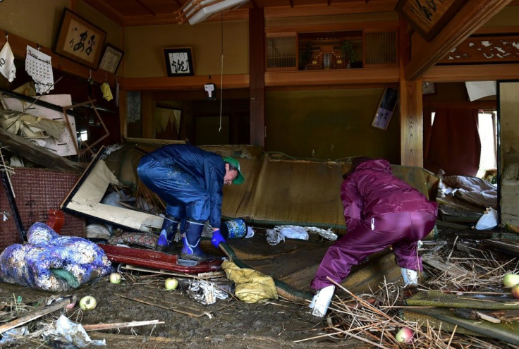 With thousands of Japanese homes without power and tens of thousands more lacking water after Typhoon Hagibis, residents clean their flood-damaged residence in Nagano