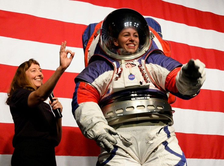 Advance space suit engineer, Kristine Davis (R), waves next to space suit engineer Amy Ross (L) during a press conference displaying NASA's next generation of space suits
