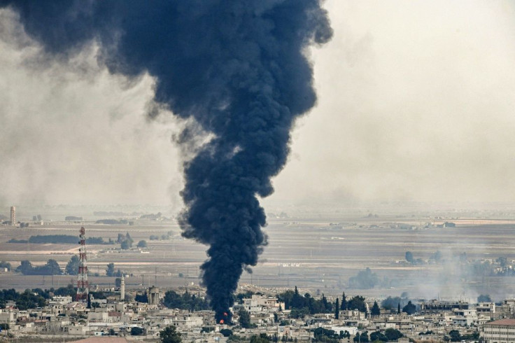 Smoke rises from the Syrian border town of Ras al-Ain whre tyres burn in a bid to blind Turkish warplanes as clashes continue across the region