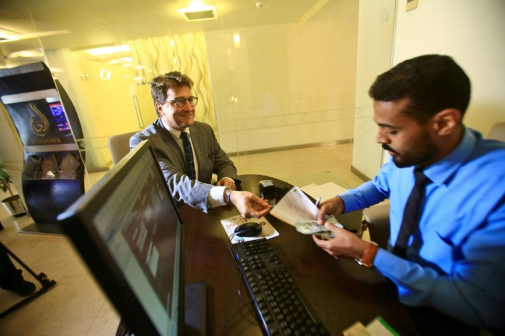 Keith Hughes, public affairs officer at the US Embassy in Khartoum, opens an account at a branch of the Bank of Khartoum