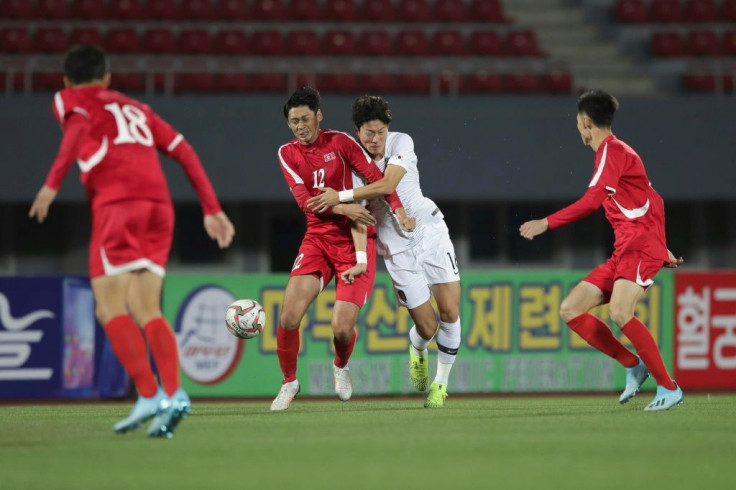 South Korea's Hwang Ui-jo and North Korea's Ri Yong Jik fight for the ball during the World Cup 2022 Qualifying match in Pyongyang