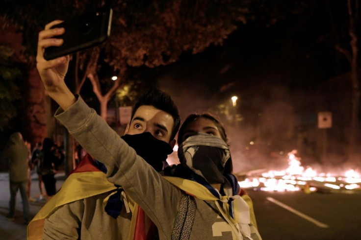 Caught on camera: two protesters take a selfie to the backdrop of burning barricades
