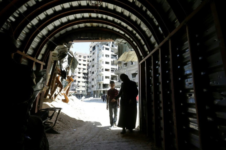 Syrians enter a tunnel leading to an underground hospital in Douma, in eartern Ghouta, a subterranean network of tunnels and makeshift wards and operating rooms beneath the former rebel enclave