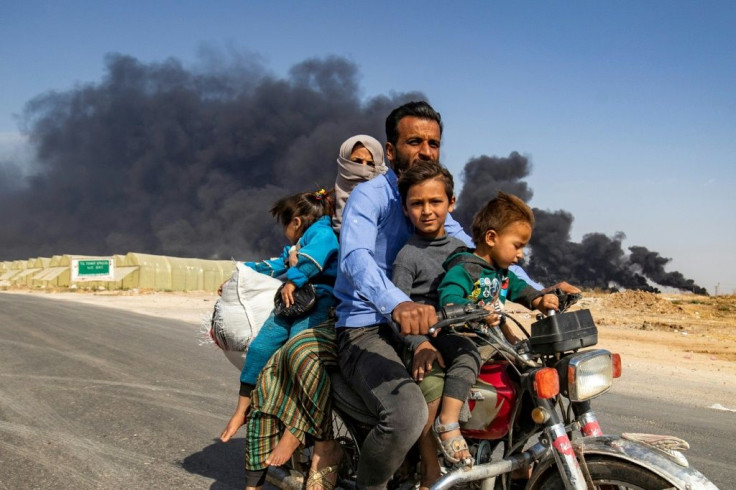 A family flees the region around Ras al-Ain by motorbike