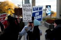 GM employee Nikki Guevara pickets outside of the General Motors Renaissance Center during a UAW GM Council Meeting that decided to send the agreement to the full workforce before ending the strike
