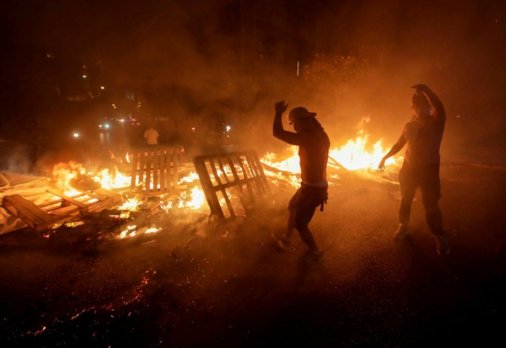 Lebanese demonstrators in Beirut burn wood and debris during a protest against new taxes