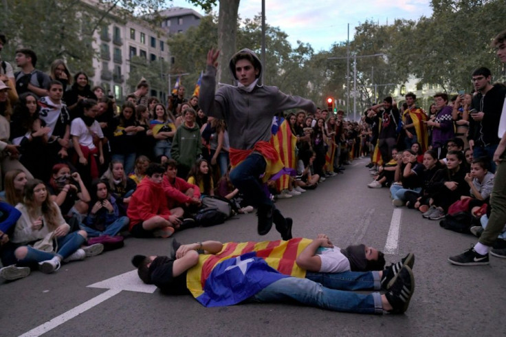 A young man jumps over two people covered with a Catalan independence flag as part of an impromptu "People's Olympics" organised by protesters in Barcelona