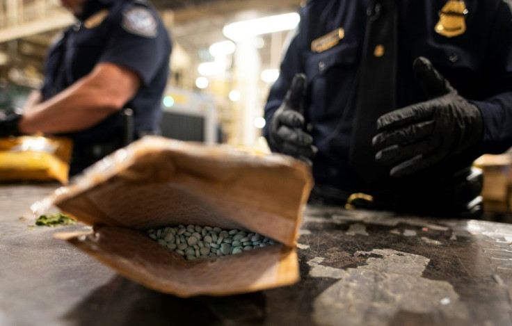 A packet of pills marked oxycodone is opened at New York's JFK airport -- the postal facility is staffed day and night to sift through packages for suspicious contents