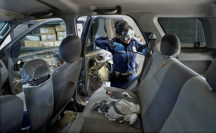 A US customs officer looks for drugs in a vehicle at California's San Ysidro border crossing on October 2, 2019