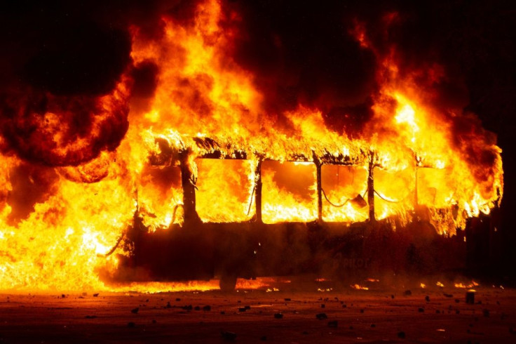 A bus burns in downtown Santiago. Protests over metro fare increases escalated into clashes with riot police, with subway stations torched and vandalised