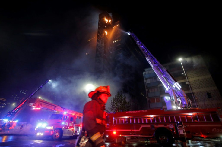 Firefighters tackle the blazing ENCEL building, which was set alight during protests in downtown Santiago