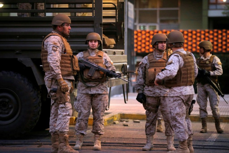 Chilean soldiers patrol the streets of Santiago in the early hours of the morning after violent protests triggered a declaration of a state of emergency