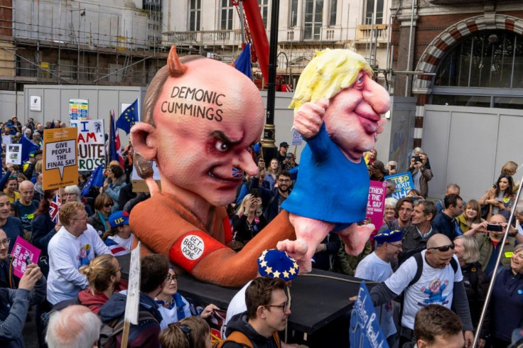 Protesters pushed an effigy depicting Prime Minister Boris Johnson as a puppet operated by his chief advisor Dominic Cummings