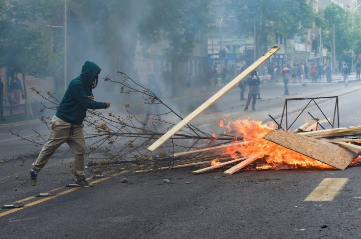 Demonstrators set up barricades during clashes between protesters and the riot police in Santiago, Chile on October 19, 2019