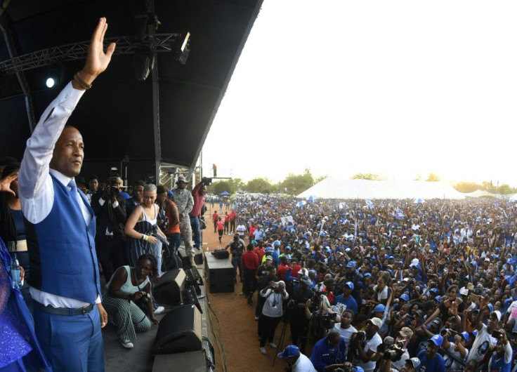Umbrella for Democratic Change leader Duma Boko greets supporters at a rally in Gaborone Saturday
