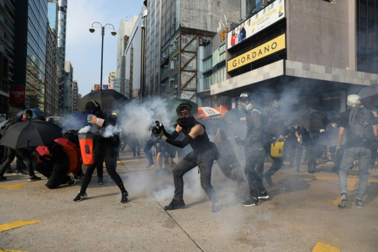 Protesters react after police fired tear gas in the Tsim Sha Tsui district of Hong Kong