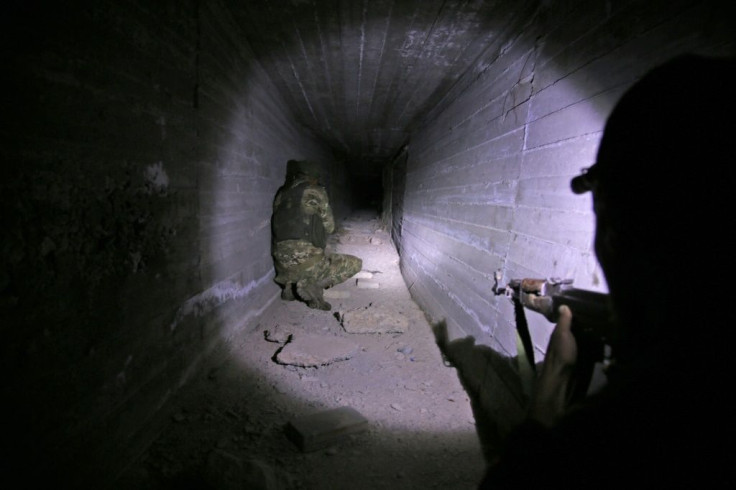 Turkish-backed Syrian fighters inspect a tunnel, said to have been built by Kurdish fighters, in the Syrian border town of Tal Abyad