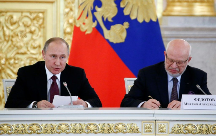 Russia's President Vladimir Putin delivers a speech during a session of the human rights council as its chairman Mikhail Fedotov takes notes back in 2016. Fedotov is now being removed from the body