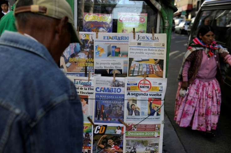 People read the front pages of newspapers Monday in La Paz, Bolivia, after the presidential election
