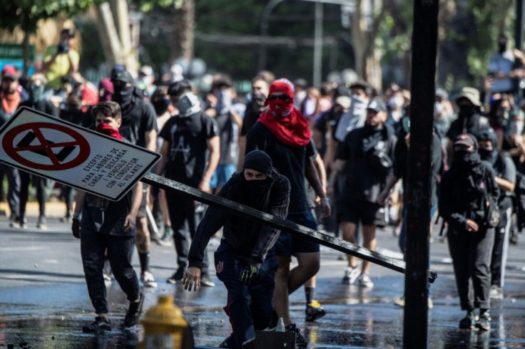 Demonstrators clash with riot police during a protest in Santiago, on October 21, 2019