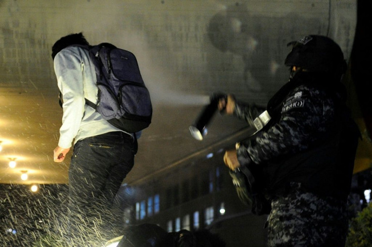 Riot police use pepper spray on a supporter of Bolivia's main opposition presidential candidate Carlos Mesa