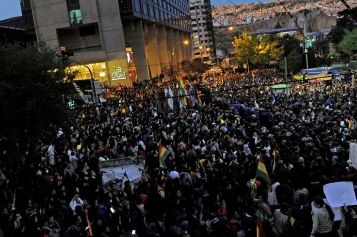 Supporters of rival Bolivia presidential candidates are separated by security forces as they gather outside the hotel where the Supreme Electoral Tribunal has its headquarters to count the election votes, in La Paz, on October 21, 2019