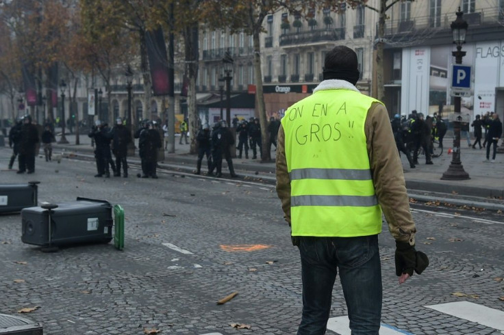 A "yellow vest" protestor faces off against French riot police on the Champs-Elysees on November 24, 2018.