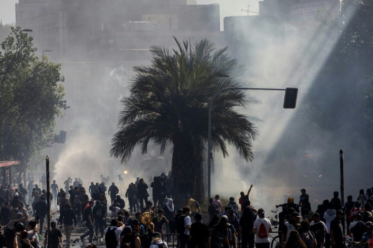 Demonstrators clash with riot police during protests in Santiago, on October 20, 2019