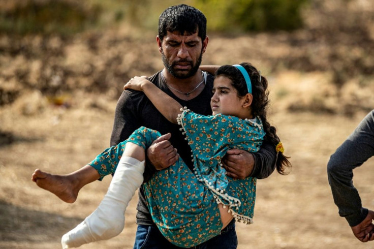 A Syrian Arab girl injured by a mortar reportedly fired from Turkish-controlled areas on Ras Al-Ain, is carried to a hospital in nearby Tal Tamr