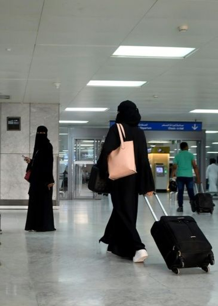 A Saudi woman rolls her suitcase at the departure hall of the Jeddah Airport
