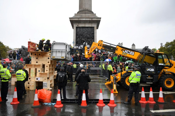 Police use heavy machinery to remove protesters from a wooden structure in Trafalgar Square in London