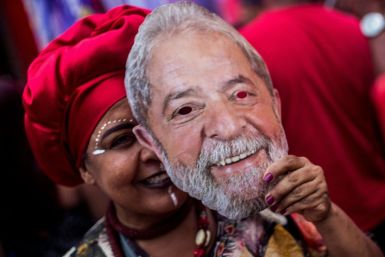 A supporter of Brazil's Workers Party holds a mask with the face of imprisoned former Brazilian president Luiz Inacio Lula da Silva