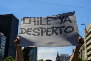 A demonstrator in Santiago holds a sign reading 'Chile has awakened'