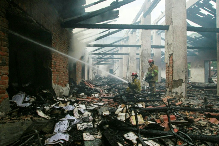 Firefighters extinguish a blaze set at the electoral court offices in the Bolivian city of Santa Cruz in protests that followed the release of disputed election results