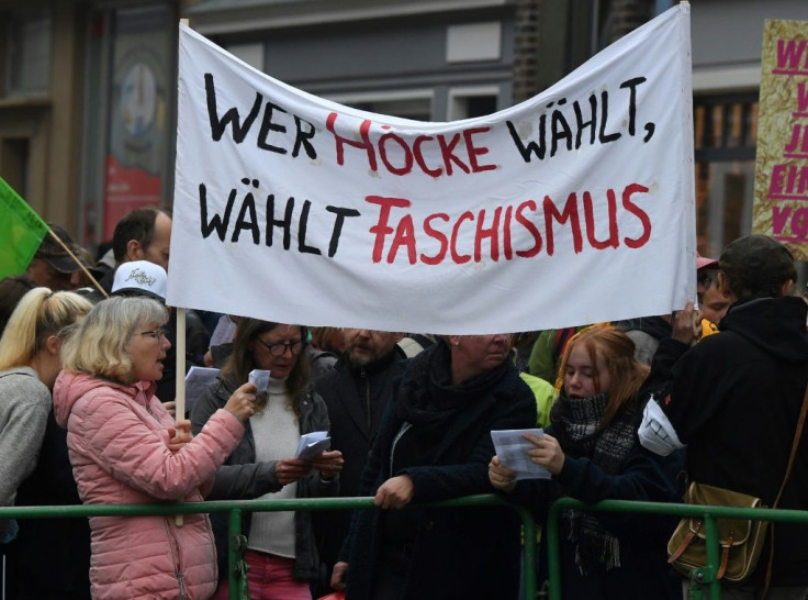 Anti-AFD demonstrators hold up a banner reading "Who votes for Hoecke votes for fascism"