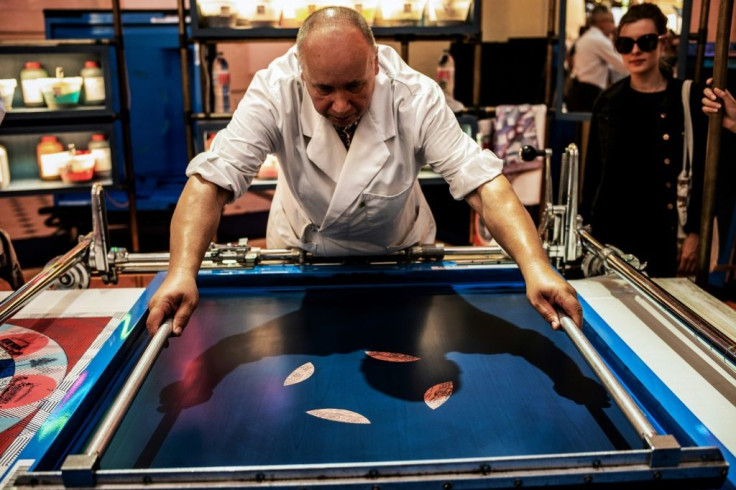 A craftsman works on a Hermes Carre scarf at a public event the French luxury goods maker held to introduce its artisans to the public