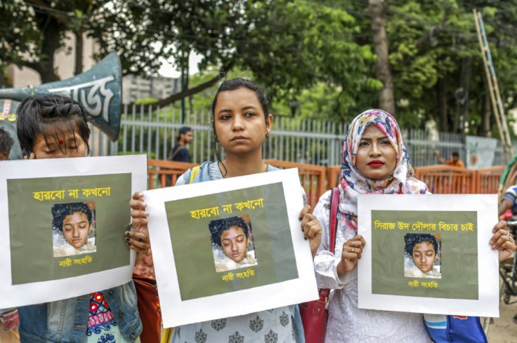 Women hold pictures of murdered teenager Nusrat Jahan Rafi during a protest in Dhaka