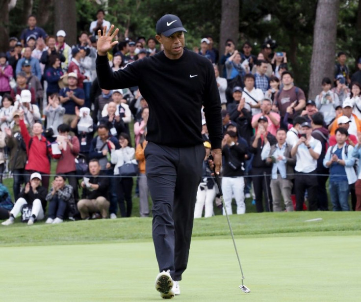 Tiger Woods acknowledges the cheers from the huge crowds at the Narashino Country Club after his seventh birdie of the day at the fifth hole and the 14th of his round