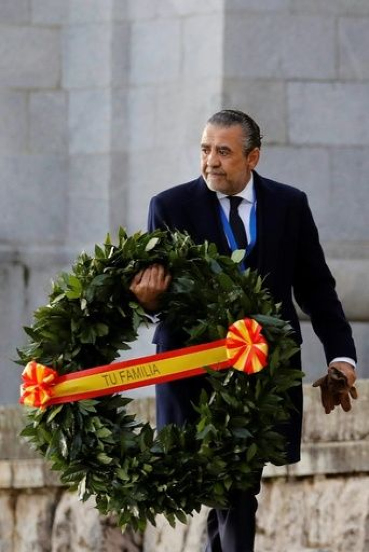 Franco's grandson, Jaime Martinez Bordiu, carries a wreath with a ribbon saying "Your family" as he arrives for the exhumation
