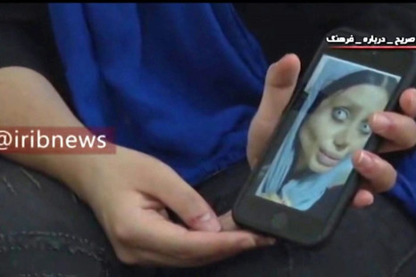 Iranian social media celebrity Sahar Tabar shows state television one of the images of herself she posted on Instagram that landed her behind bars
