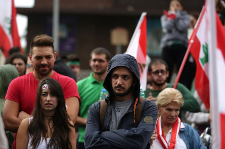 Lebanese protesters listen to a speech by President Michel Aoun