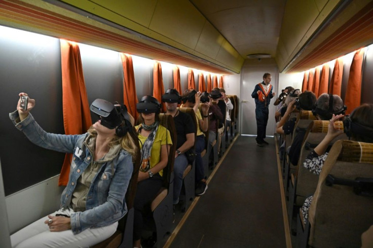 Reporters get to grips wth Timeride's tours using VR goggles -- choosing from a trio of characters to "lead" them through the city